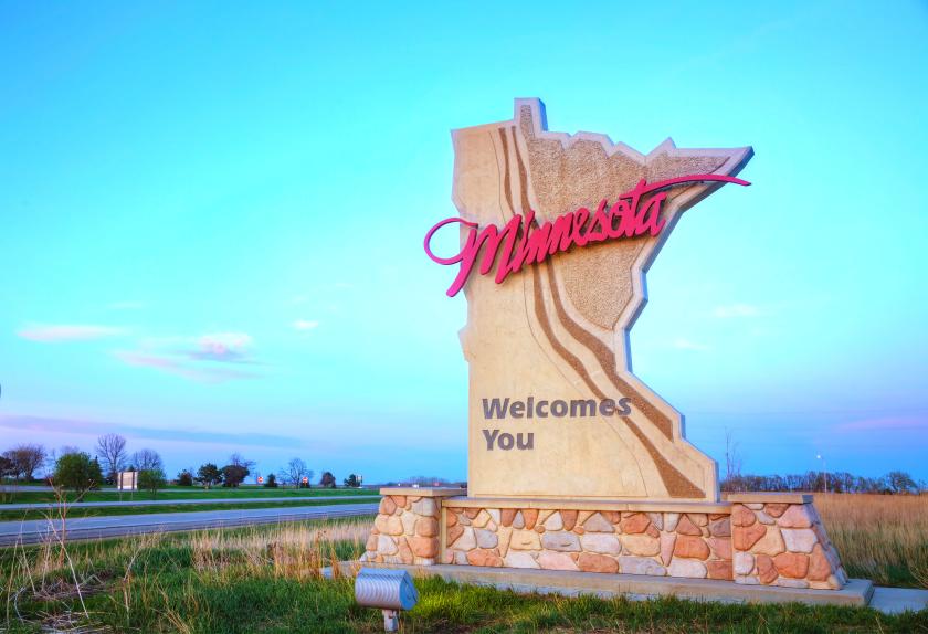 A sign shaped like the state of Minnesota with the phrase "Minnesota Welcomes You" written across it