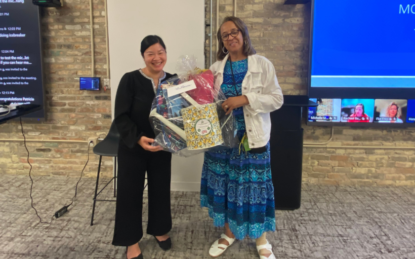 Michelle and Patricia pose together holding a basket of gifts